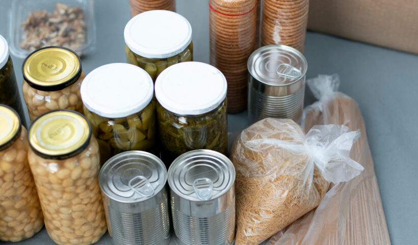 Vorratslagerung mit haltbaren Lebensmitteln in Gläsern und Dosen: Eingelegte Bohnen, Oliven, Artischocken, Konserven sowie Reis und Nudeln in Plastikbeuteln – Beispiel für platzsparende und langlebige Krisenvorsorge.